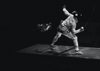 A fencer stands in a defensive position.