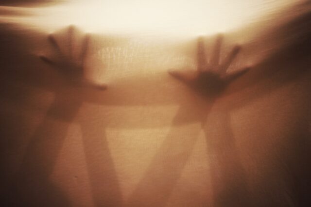 Two hands pressed against fabric